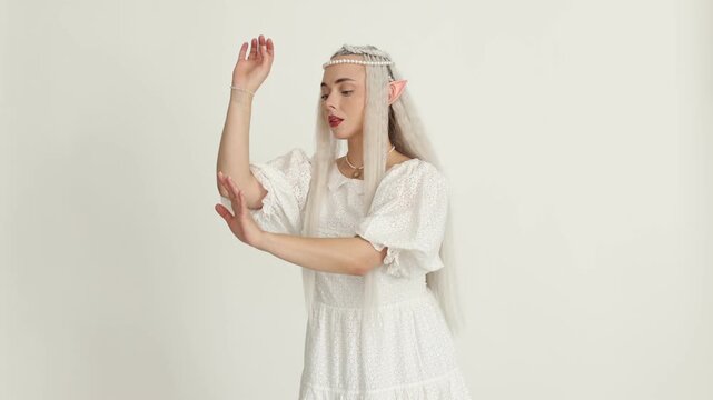 Beautiful girl dressed as elf on white background