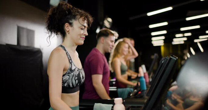 Group of friends exercises together at fitness center with energetic mood and teamwork while using gym equipment and enjoying shared fitness goals