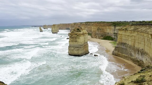 Powerful ocean waves crashing against the dramatic cliffs at the Loch Ard Gorge viewpoint near the Twelve Apostles on the Great Ocean Road, Victoria, Australia