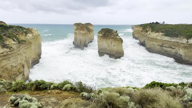 Powerful ocean waves crashing against the dramatic cliffs at the Loch Ard Gorge viewpoint near the Twelve Apostles on the Great Ocean Road, Victoria, Australia