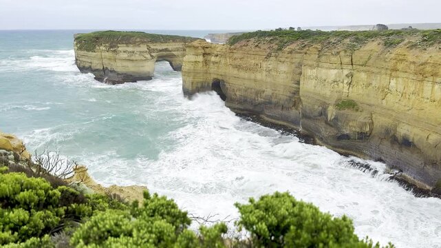Powerful ocean waves crashing against the dramatic cliffs at the Loch Ard Gorge viewpoint near the Twelve Apostles on the Great Ocean Road, Victoria, Australia
