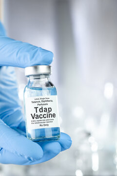Healthcare concept with a hand in blue medical gloves holding Tdap, tetanus diphtheria and pertussis or whooping cough, vaccine vial