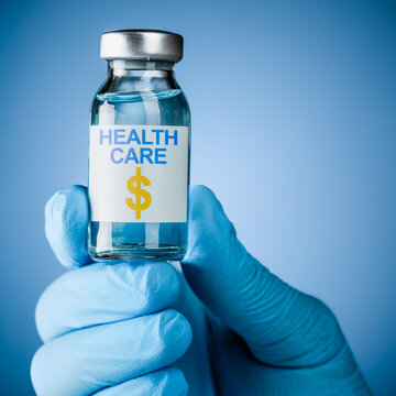 Nurses hand in blue medical gloves holding a vaccine bottle with Healthcare and a dollar sign text. Concept for the expense cost of health care, medical debt, and the high price of pharmaceuticals.