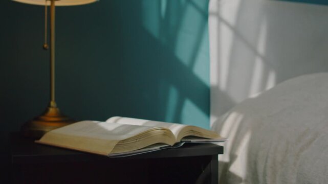 Beautiful macro shot: an open book on a nightstand in a cozy bedroom. Sunlight streams through the window as a light breeze gently turns the pages, curtains moving softly, serene and dreamy mood.