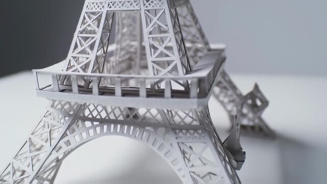 Detailed close-up of a paper Eiffel Tower model, featuring intricate cutouts and structural design