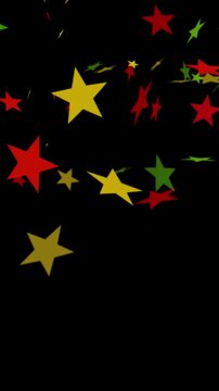 Confetti of stars falling in bold red, yellow, and green colors on black background for Juneteenth, or Freedom Day, to commemorate the ending of slavery June 19th 1865 in the United States of America.