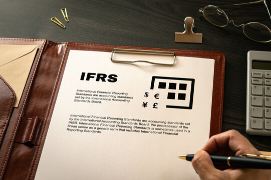 International Financial Reporting Standard: Realistic mock-up mock placed on  with pen, clips, glasses. Contributor-created fictional business document for illustrative purposes.