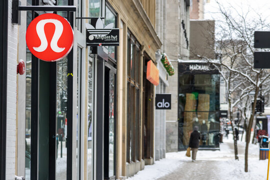 MONTREAL, CANADA, 25 December 2025 : Shopping street in winter with store signs and snow