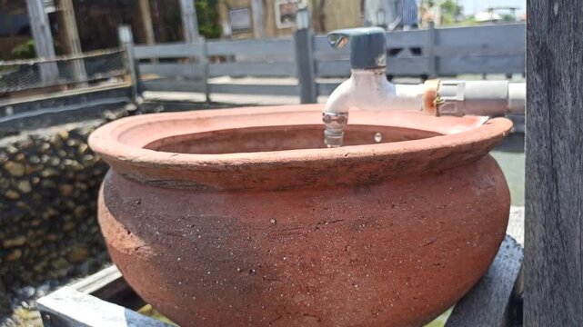 A simple handwashing station using a clay jar, offering a traditional and natural way to maintain hygiene with an earthy and rustic aesthetic.