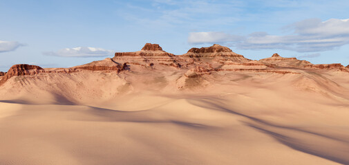 Fototapeta premium Vast Desert Sand Dunes With Red Rock Mesas Under Blue Sky — 3D Rendering Landscape Scene