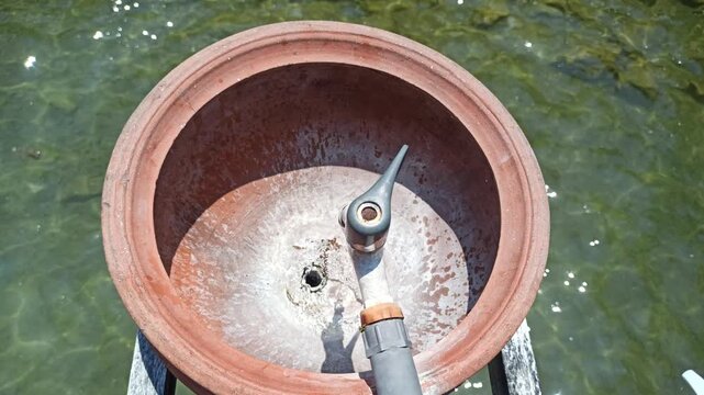 A simple handwashing station using a clay jar, offering a traditional and natural way to maintain hygiene with an earthy and rustic aesthetic.
