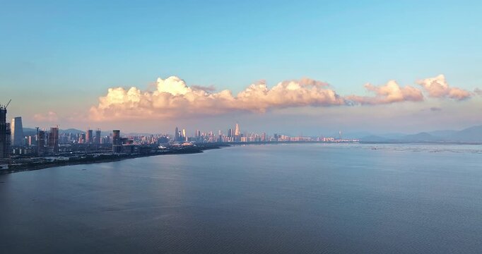 Aerial view of Shenzhen coastal city skyline with modern skyscrapers and sea at sunset, Guangdong, China.