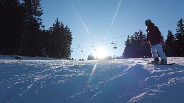Snowboarder Girl Carves Down Sunny Slope at Kopaonik Mountain Resort in Serbia, Enjoying Winter Sports