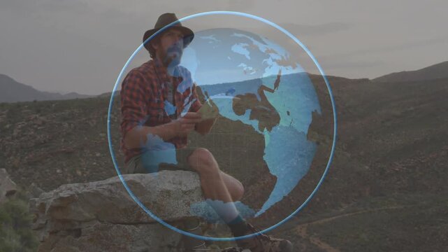 Man starting writing in book on rock ledge, rotating globe overlay shifting map for travel planning