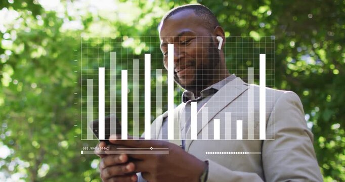Man under tree tapping phone on ping, earbuds playing audio, chart showing positive data, laughing