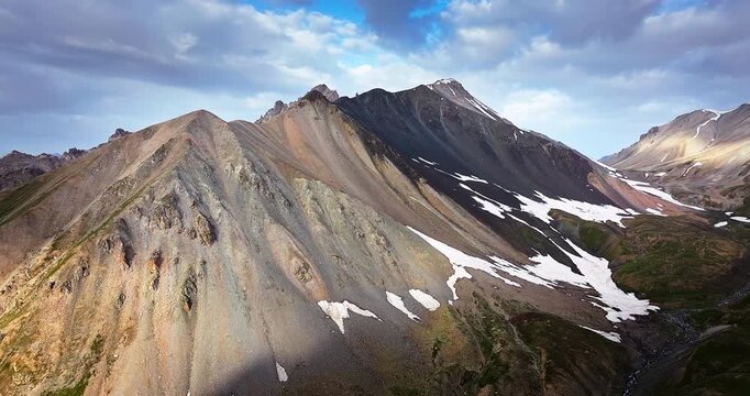Aerial view of rugged mountain peaks with melting snow patches and rocky terrain, the Tianshan Mountains, Xinjiang, China