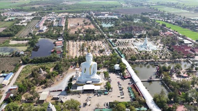 Drone flight forward to Big Buddha statue showing various Buddhist buildings in Suphan Buri