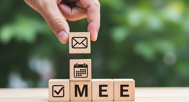Hand holding wooden block with email over stacked blocks spelling M E