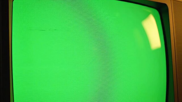 A vintage television screen displaying a green video test pattern in a dark room