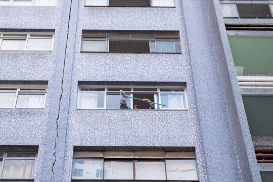 Curitiba, Brasil - Mujer limpiando la ventana de su apartamento.
