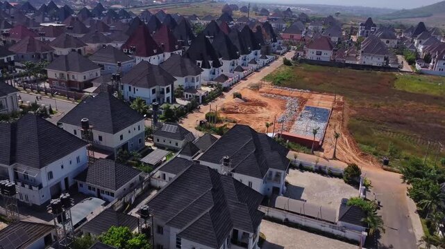 Stunning aerial of a large suburban neighborhood with a plot of land still under development in Abuja, Nigeria on a sunny day