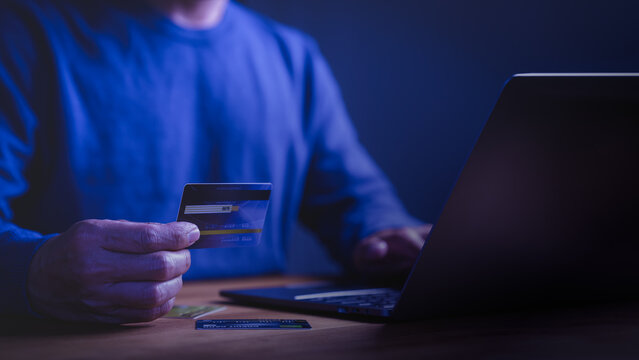 Person using credit card for online shopping and digital payment on laptop. Secure e-commerce finance, banking, and business transaction concept for internet security.