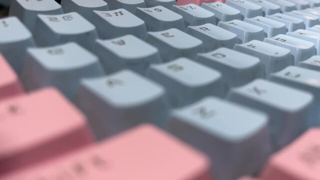 Pastel mechanical keyboard in close up on desk creating clean, modern, and minimalist workspace atmosphere.