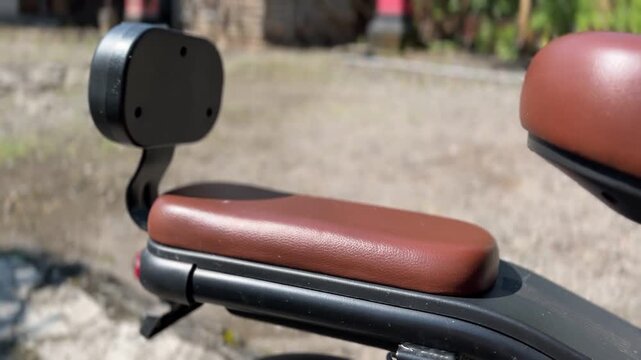 Close up bicycle seat with backrest outdoors highlighting comfort, mobility, and modern lifestyle atmosphere.