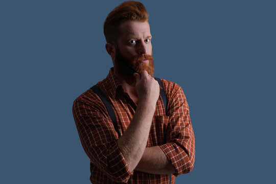 Barbershop professional. Bearded man with red beard. Hairstylist at barber shop isolated on grey. Barber using hair comb. Brutal hairdresser combing beard hair. Hairstylist at barber shop