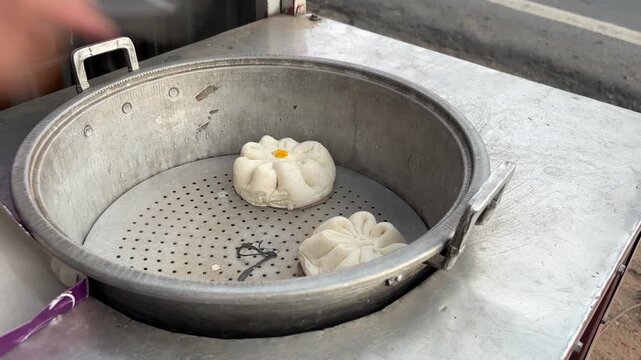 The process of taking the soft and fluffy traditional Chinese steamed buns (bakpao) after steaming.