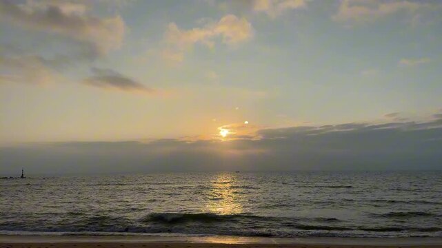 A serene 4K horizontal shot of a golden sunset over the Hainan ocean horizon, including high-quality ambient audio of gentle waves lapping the shore.