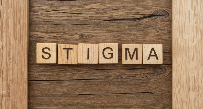Word stigma spelled out with wooden blocks placed creatively on rustic wooden background with shapes