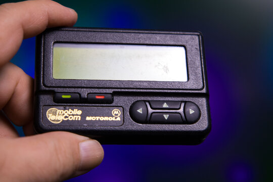 Motorola pager held in hand with mobile telecom branding visible