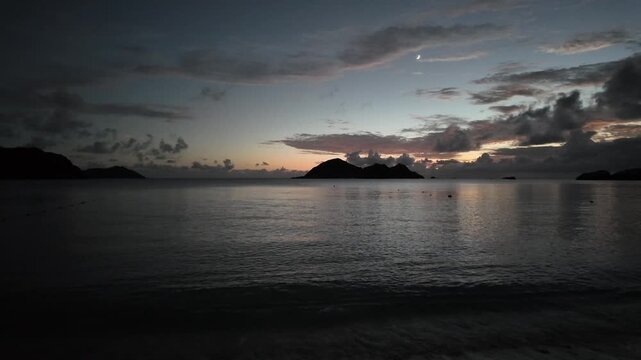 渡嘉敷島・阿波連ビーチから望む夕日とハナリ島（シブがき島）のシルエット 慶良間諸島 動画素材 4K