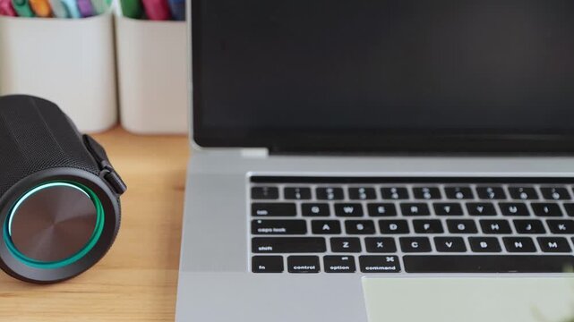 Track Shot Smart Speaker Virtual Assistant or Artificial Intelligence Concept with Laptop Computer on Office Desk
