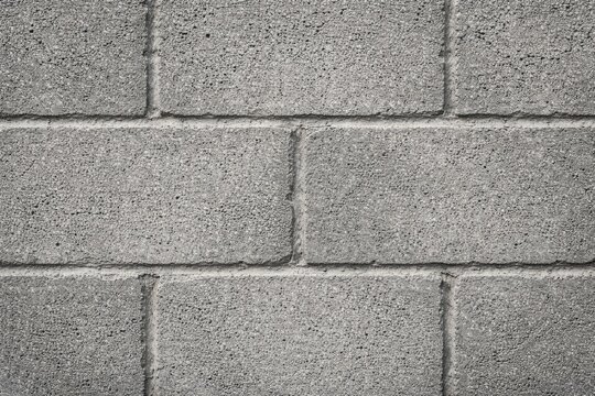 Detailed close up of a gray textured cinderblock wall surface