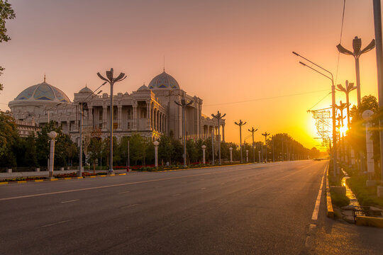 Ismoil Somoni Avenue in Dushanbe, Tajikistan, with Navruz Palace at sunset with grand architecture and a wide empty boulevard.
