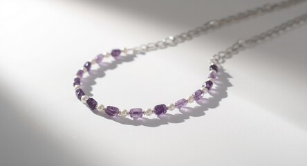 Obraz premium Delicate handmade necklace with amethyst quartzite and pearl beads on silver over white backdrop with shadow