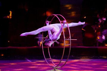 A teenage girl performs an acrobatic act on a circus ring. Concept is that children are involved in sports and circus arts © Anna