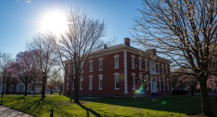 Fototapeta premium Springtime building scene featuring radiant sunlight and blue sky