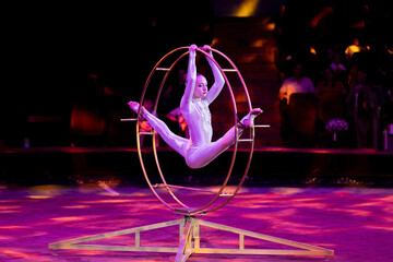 A teenage girl performs an acrobatic act on a circus ring. Concept is that children are involved in sports and circus arts © Anna