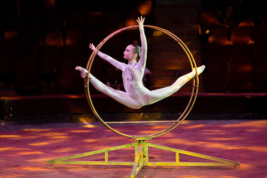 A teenage girl performs an acrobatic act on a circus ring. Concept is that children are involved in sports and circus arts