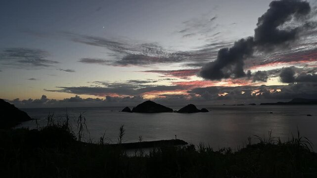 渡嘉敷島・阿波連ビーチから望む夕日とハナリ島（シブがき島）のシルエット 慶良間諸島 動画素材 4K