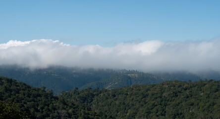 Obraz premium Natural terrain hidden beneath smoke and low cumulus cloud cover
