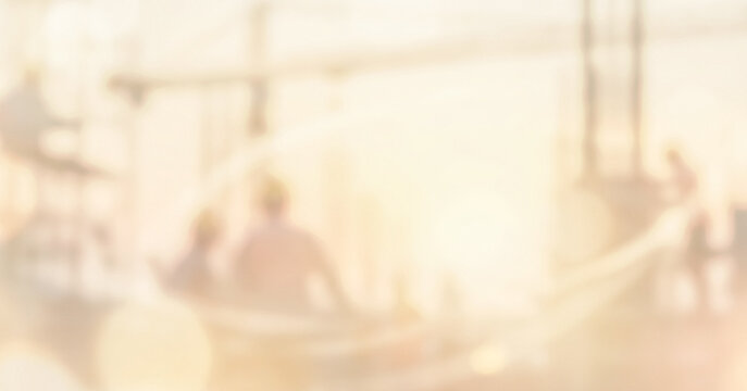 A serene, dreamy image depicting people enjoying a sunset by the water, creating a tranquil atmosphere with soft, blurred lines and warm tones.