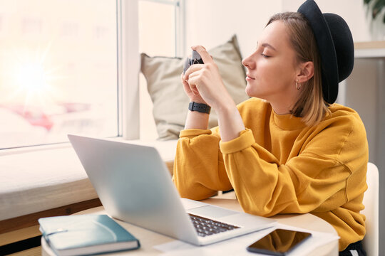 Female photographer with camera, laptop and smart phone at cafe