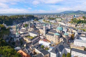 Fototapeta premium View from the medieval Hohensalzburg Castle of the historic Salzburg, Austria old town from the Petersfriedhof cemetery to the Salzach River, with a festival going on in Domplatz Square.