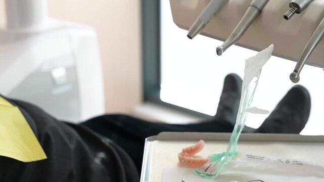 Detailed close-up shot of a dental procedure with tools, showcasing a dental mold in a clinic setting, highlighting equipment and professional care. Bright, clinical lighting enhances clarity.