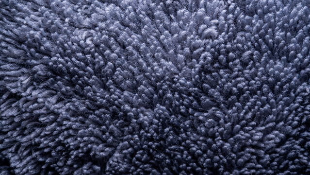 abstract texture of blue-dark fleece fabric with a soft and messy fiber arrangement providing a cozy and neutral background for professional creative projects
