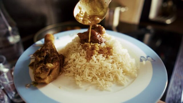 Pouring Savory Gravy Sauce Over Rice And Roasted Chicken Leg.  Preparation Of Steamed Basmati Rice With Poultry